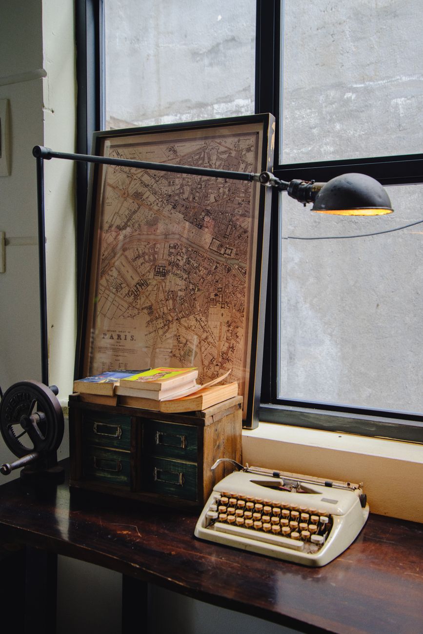 Travel writer examining maps in a sunlit historic library room
