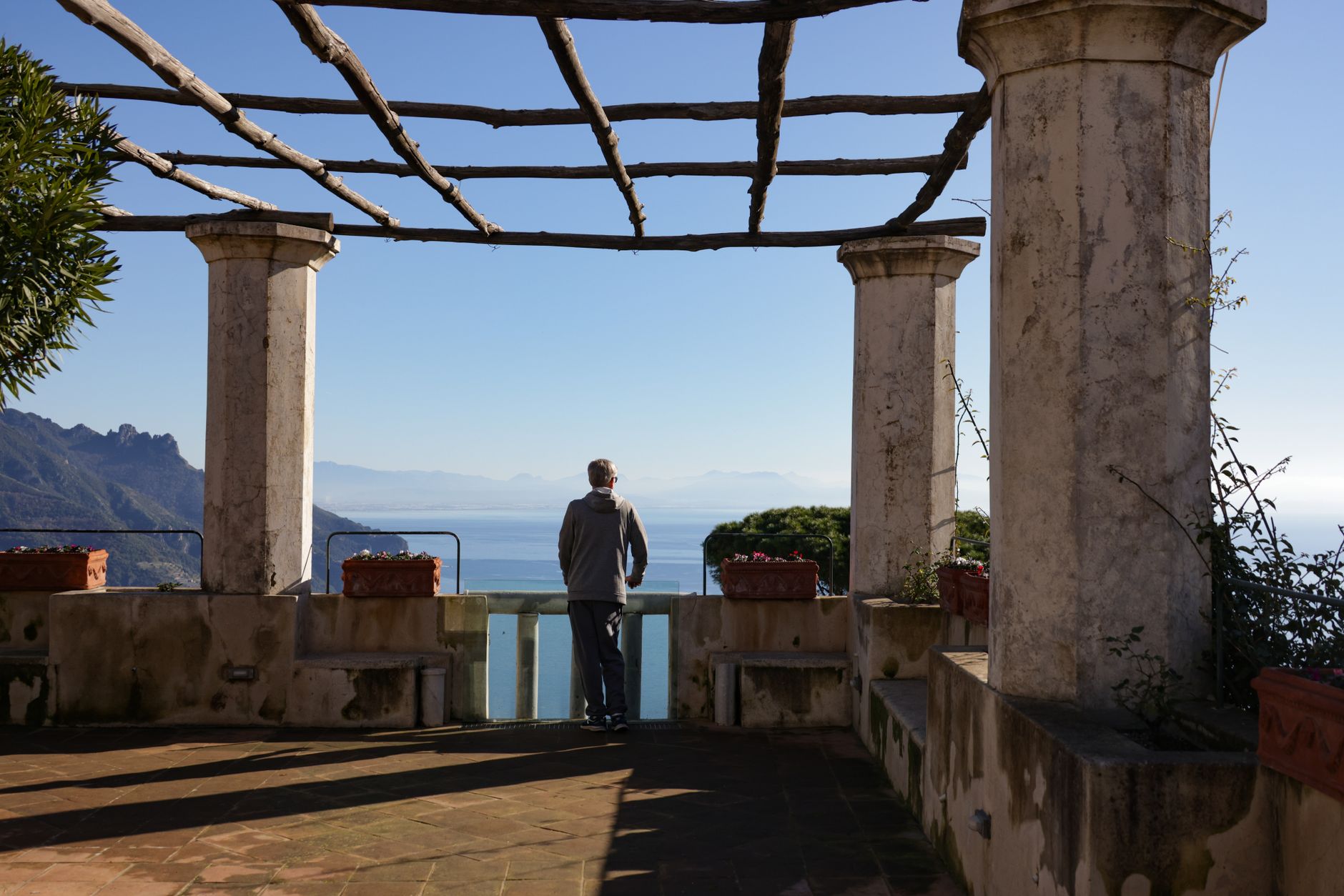 Arched cloister walkway framing Mediterranean blue sea